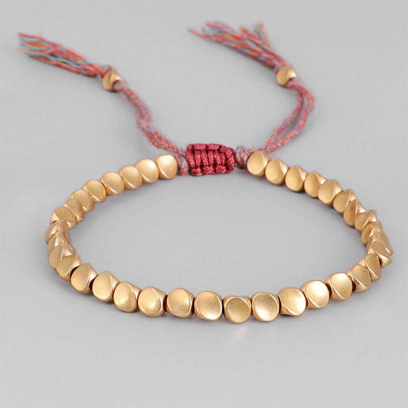 Bracelet bouddhiste en perles de cuivre et cordon coloré