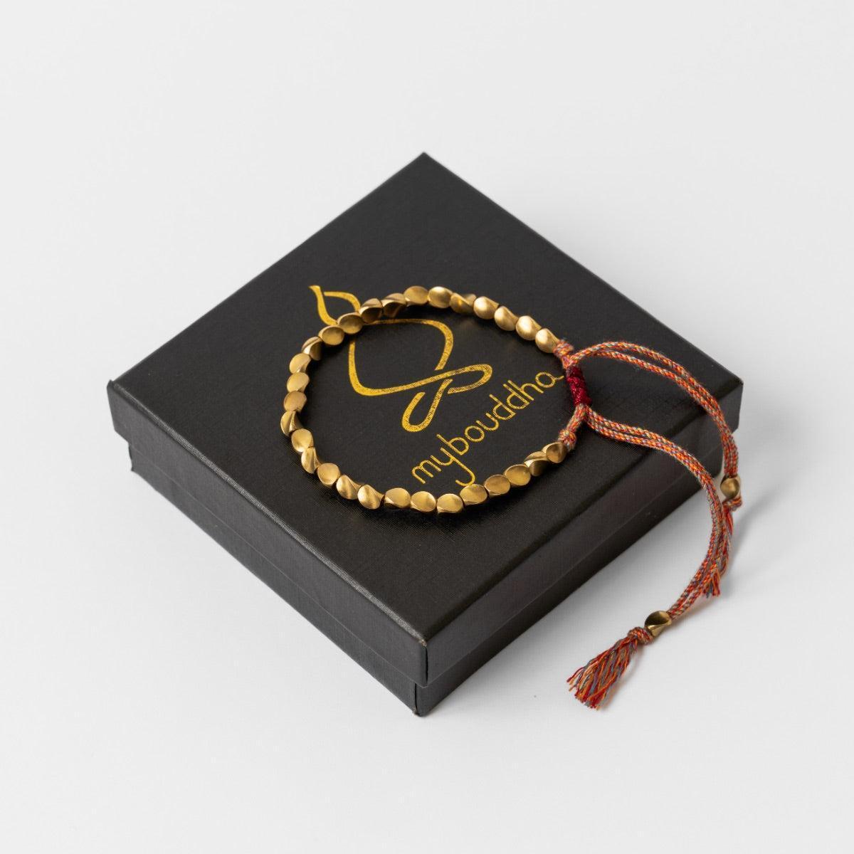 Bracelet bouddhiste en perles de cuivre et cordon coloré