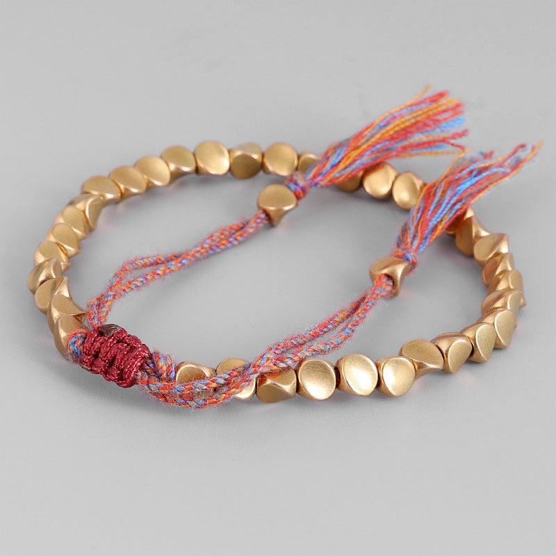 Bracelet bouddhiste en perles de cuivre et cordon coloré