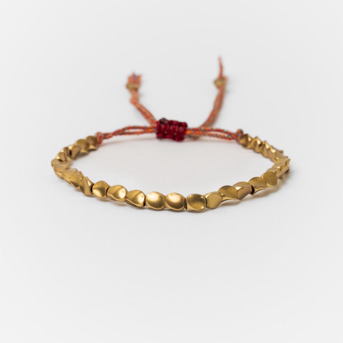 Bracelet bouddhiste en perles de cuivre et cordon coloré