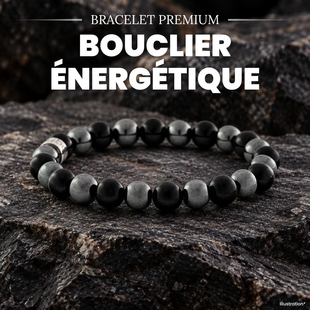 Bracelet bouclier énergétique en hématite et perles noires, posé sur des roches sombres, ambiance minérale