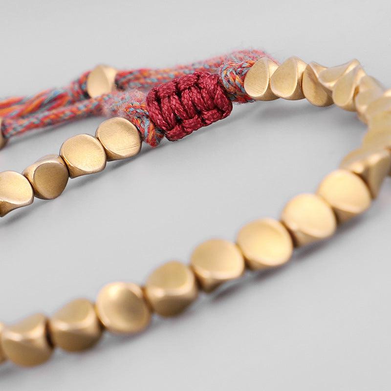 Bracelet bouddhiste en perles de cuivre et cordon coloré