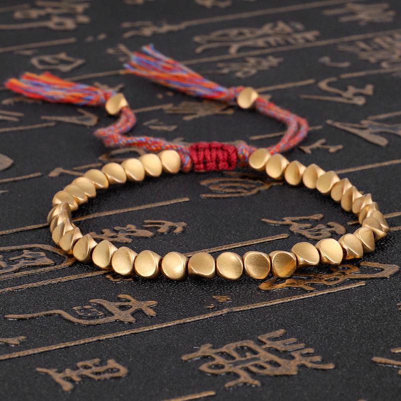 Bracelet bouddhiste en perles de cuivre et cordon coloré