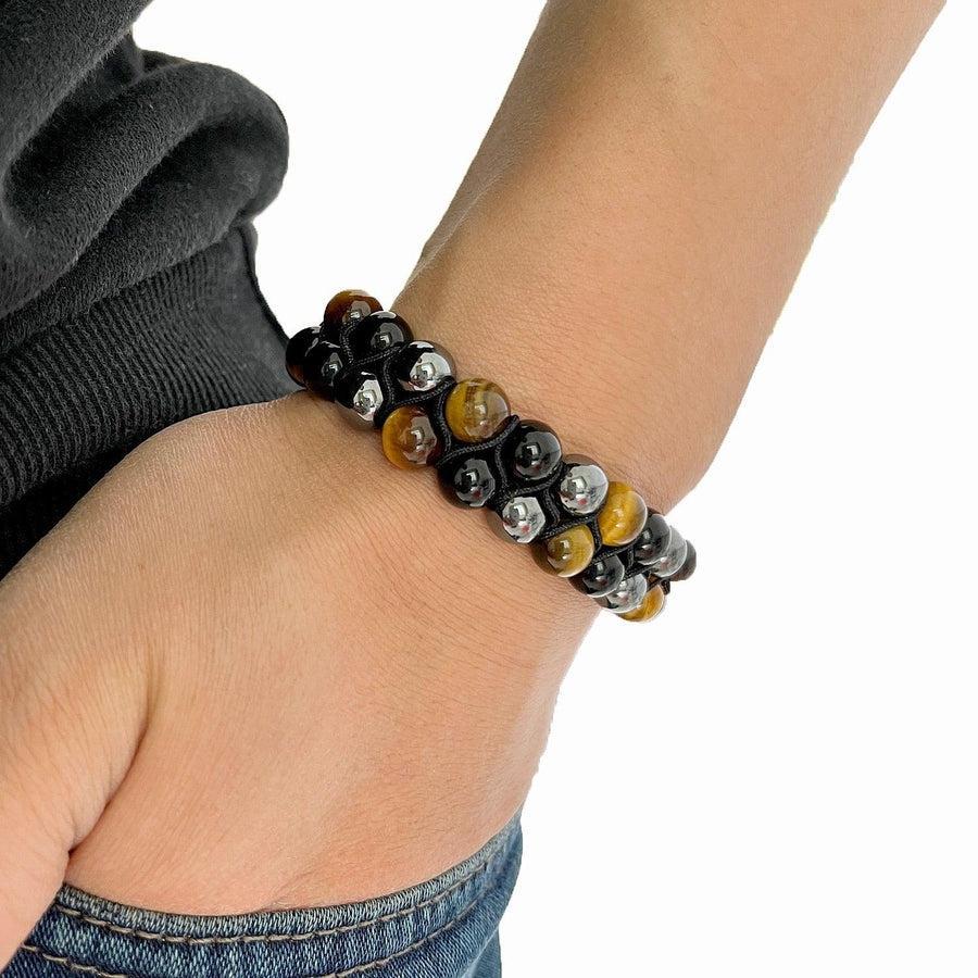 Double bracelet shamballa porté au poignet, perles noires, grises et dorées sur peau claire