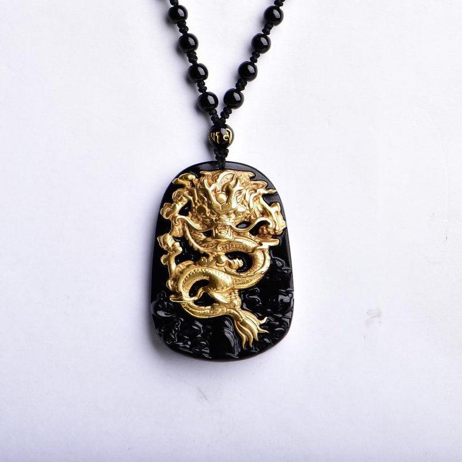 Pendentif plaquée or représentant un dragon sur une pierre d'obsidienne noire